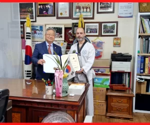 Mestre Alexsandro Albano Benitz recebendo a certificação de 5° Dan da World Taekwondo Chang Moo Kwan
